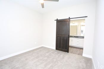 an empty living room with a wooden sliding door to a bathroom at Century Baxter Avenue, Louisville